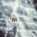 mujer haciendo yoga en una catarata