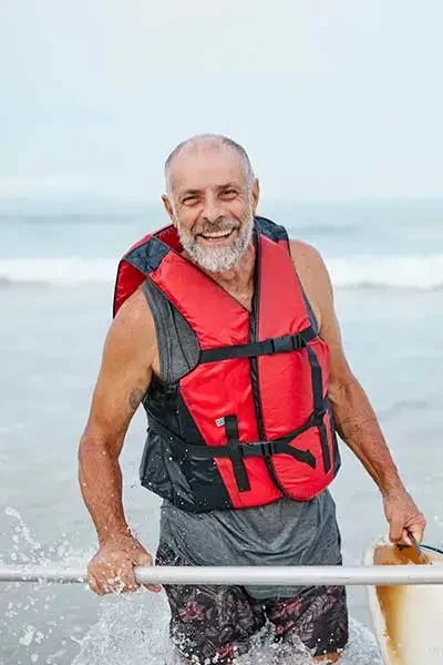 señor mayor saliendo del mar con una canoa